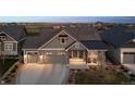 Charming home featuring stone accents, a three-car garage, and covered porch with seating area at 2882 Heron Lakes Pkwy, Berthoud, CO 80513