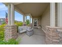 Cozy front porch with stone columns and comfortable seating, perfect for relaxing outdoors at 23831 Eagle Bend Ln, Parker, CO 80138