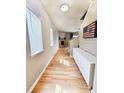 Hallway featuring hardwood floors, white trim, and a view of the fireplace at 23831 Eagle Bend Ln, Parker, CO 80138