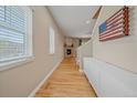 Inviting hallway featuring hardwood floors, fireplace in view, and natural light from window at 23831 Eagle Bend Ln, Parker, CO 80138
