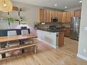 Open kitchen featuring an island, granite countertops, stainless appliances, and wood cabinetry at 23831 Eagle Bend Ln, Parker, CO 80138