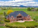 Aerial of the back exterior of brick home features a patio and stairwell with expansive green lawn at 2366 Shoreside Dr, Berthoud, CO 80513