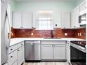 Modern kitchen with stainless steel appliances, light cabinets, and brick backsplash at 7423 S Quail Cir # 1533, Littleton, CO 80127
