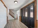 Inviting entryway with new gray flooring, staircase and closet, and stylish front door at 7746 S Harrison Cir, Centennial, CO 80122