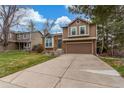 A charming home with brick and wood siding and a concrete driveway offers curb appeal and functionality at 5307 E Courtney Ave, Castle Rock, CO 80104