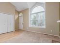 Bright living room featuring large arched window, plush carpet, and adjacent closet space at 5307 E Courtney Ave, Castle Rock, CO 80104