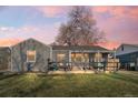 Charming single-story home featuring a cozy front porch and well-maintained lawn at twilight at 3270 S Galapago St, Englewood, CO 80110