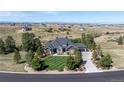 Aerial view of a luxurious home with a meticulously striped lawn and lush landscaping in a serene, expansive setting at 9563 Red Primrose St, Franktown, CO 80116