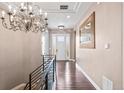 Elegant foyer featuring a modern chandelier, hardwood floors, and a view of the front door at 9563 Red Primrose St, Franktown, CO 80116