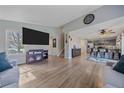 Bright and open living space with hardwood floors, large TV, and a view into the kitchen area at 8414 Coralberry Ct, Parker, CO 80134