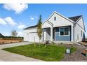 Beautiful home with well-kept lawn, tidy landscaping, and charming white and blue siding detail at 761 Muturu Rd, Johnstown, CO 80542
