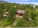 Panoramic aerial view of a brown two-story home surrounded by lush trees and greenery at 776 Hilltop Rd, Palmer Lake, CO 80133