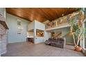 Bright living room with high wood ceiling, stone fireplace and view of loft at 776 Hilltop Rd, Palmer Lake, CO 80133