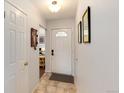 Bright entryway with tile flooring and coat closet, leading to other rooms in the house at 6930 S Delaware St, Littleton, CO 80120