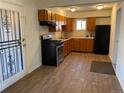 The cozy kitchen features wood cabinets, modern appliances, and vinyl plank floors at 945 Zenobia St, Denver, CO 80204