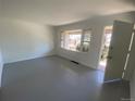 Open living room featuring fresh paint, vinyl floors, and bright sunny window views at 945 Zenobia St, Denver, CO 80204