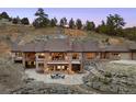 Expansive hillside home featuring large windows and multiple outdoor spaces for enjoying the view at 21609 Clarence Ln, Golden, CO 80401