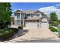 Beautiful two-story home with stone accents, a three-car garage, and a well-maintained lawn at 9278 E Aspen Hill Pl, Lone Tree, CO 80124