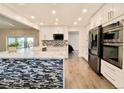 Modern kitchen with stainless appliances, white cabinets, and a mosaic tile backsplash at 5126 S Kenton Way, Englewood, CO 80111