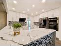 Stylish kitchen with quartz countertops, white cabinets, and stainless steel appliances at 5126 S Kenton Way, Englewood, CO 80111