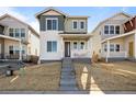 Inviting two-story home featuring a welcoming front porch and meticulously landscaped yard at 5936 N Lisbon St, Aurora, CO 80019