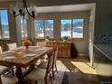 Sunlit dining room with rustic wooden table and views of the snow covered mountains at 656 County Road 72, Bailey, CO 80421