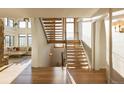 Grand wooden staircase with wrought iron railing and bright natural light at 9356 Cherrywood Trl, Littleton, CO 80127
