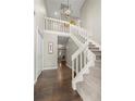 Inviting foyer with hardwood floors, a staircase with white railing, and a stylish light fixture at 1285 Aberdeen Dr, Broomfield, CO 80020