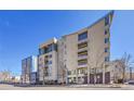 Modern condo building showcasing architectural details and multiple floors with balconies under clear blue skies at 290 W 12Th Ave # 205, Denver, CO 80204