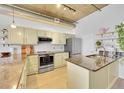 Modern kitchen with stainless steel appliances, granite countertops, light wood floors and exposed ceiling at 290 W 12Th Ave # 205, Denver, CO 80204