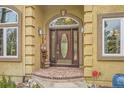 Inviting front entrance featuring a wood door, brick accents, and decorative welcome sign at 19375 Sherwood Trl, Monument, CO 80132