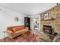 Inviting living room with stone fireplace, stylish rug, and cozy seating area at 4460 S Pitkin St # 119, Aurora, CO 80015