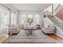 Bright living room with light hardwood floors, a neutral color palette, and a cozy seating arrangement at 13360 W 83Rd Pl, Arvada, CO 80005