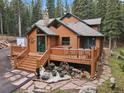 Log cabin showcasing a welcoming porch with stone pathway and lush green surroundings at 8905 Carol Ln, Conifer, CO 80433
