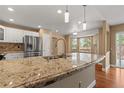Bright kitchen featuring granite countertops, stainless steel appliances, and hardwood floors at 17519 E Caspian Pl, Aurora, CO 80013