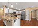 Modern kitchen with white cabinetry, stainless steel appliances, and a center island with granite countertops at 17519 E Caspian Pl, Aurora, CO 80013