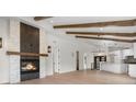 Open-concept living space with vaulted ceilings, exposed beams, fireplace, and a view into the updated kitchen at 2665 Juilliard St, Boulder, CO 80305