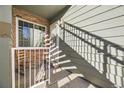 Close-up of the balcony, with brick and vinyl siding, concrete floor, and white railing at 868 S Reed Ct # H, Lakewood, CO 80226