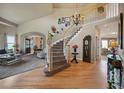 Grand foyer featuring a curved staircase, hardwood floors, and a chandelier, creating an inviting entrance at 10520 W Vassar Dr, Lakewood, CO 80227