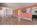 Spacious living room featuring wood flooring, built in shelving, and ample natural light at 8289 Race St, Denver, CO 80229