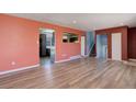 Open-concept living room with wood floors, seamlessly connects to a kitchen and staircase at 8289 Race St, Denver, CO 80229