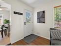 Inviting entryway with hardwood floors, modern art, and a bright white door with window panes at 4740 W Wyoming Pl, Denver, CO 80219