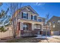 Charming home with a cozy front porch, complemented by manicured landscaping and mature trees at 17806 Coral Burst St, Parker, CO 80134