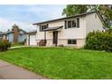 Classic home featuring a lush green lawn, attached garage, and welcoming front entrance at 7912 Fenton St, Arvada, CO 80003