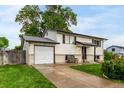 Traditional home featuring a well-manicured lawn, attached garage, and a cozy front porch at 7912 Fenton St, Arvada, CO 80003