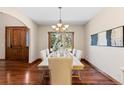 Formal dining room featuring hardwood floors, neutral paint, chandelier, and a large window at 5414 Golden Currant Way, Parker, CO 80134