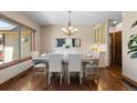 Bright dining room features hardwood floors, neutral paint, chandelier, and a large window at 5414 Golden Currant Way, Parker, CO 80134