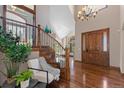 Grand foyer with hardwood floors, staircase, wrought iron railing, high ceilings and modern chandelier at 5414 Golden Currant Way, Parker, CO 80134