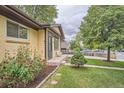 Beautifully landscaped front yard with lush green grass and vibrant flower beds, showcasing the home's charm at 7618 Umatilla St, Denver, CO 80221