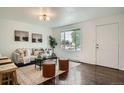 Bright living room with hardwood floors, neutral décor, large window, and comfortable seating with stylish accents at 7618 Umatilla St, Denver, CO 80221